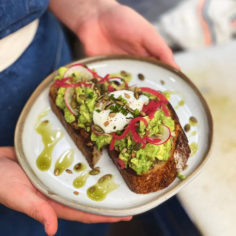 Avocado tartine on sourdough with pickled onions and herbs